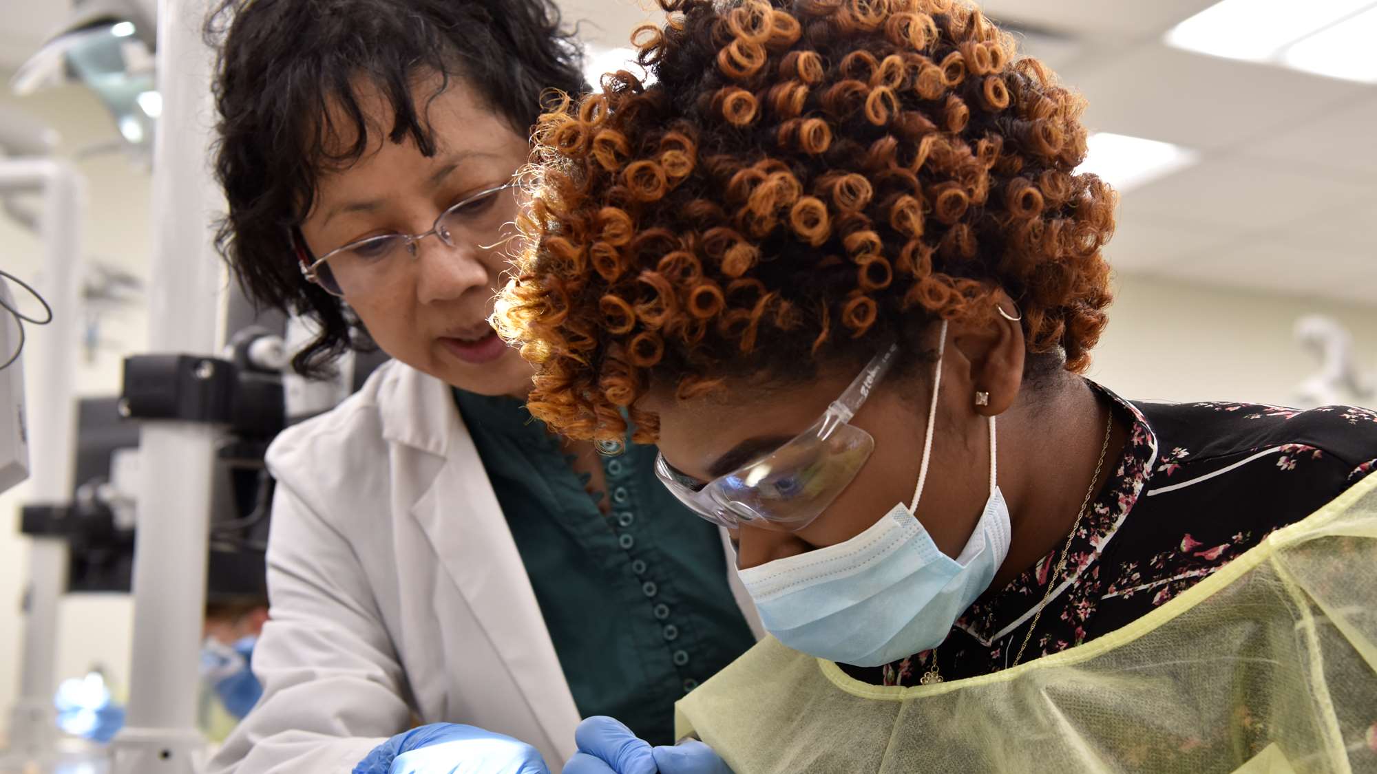 A potential student is guided through an exercise while visiting the dental school.