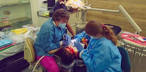 DDS student and assistant providing dental care to young patient